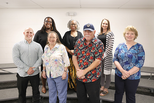 Staff members stand with awards for years of service